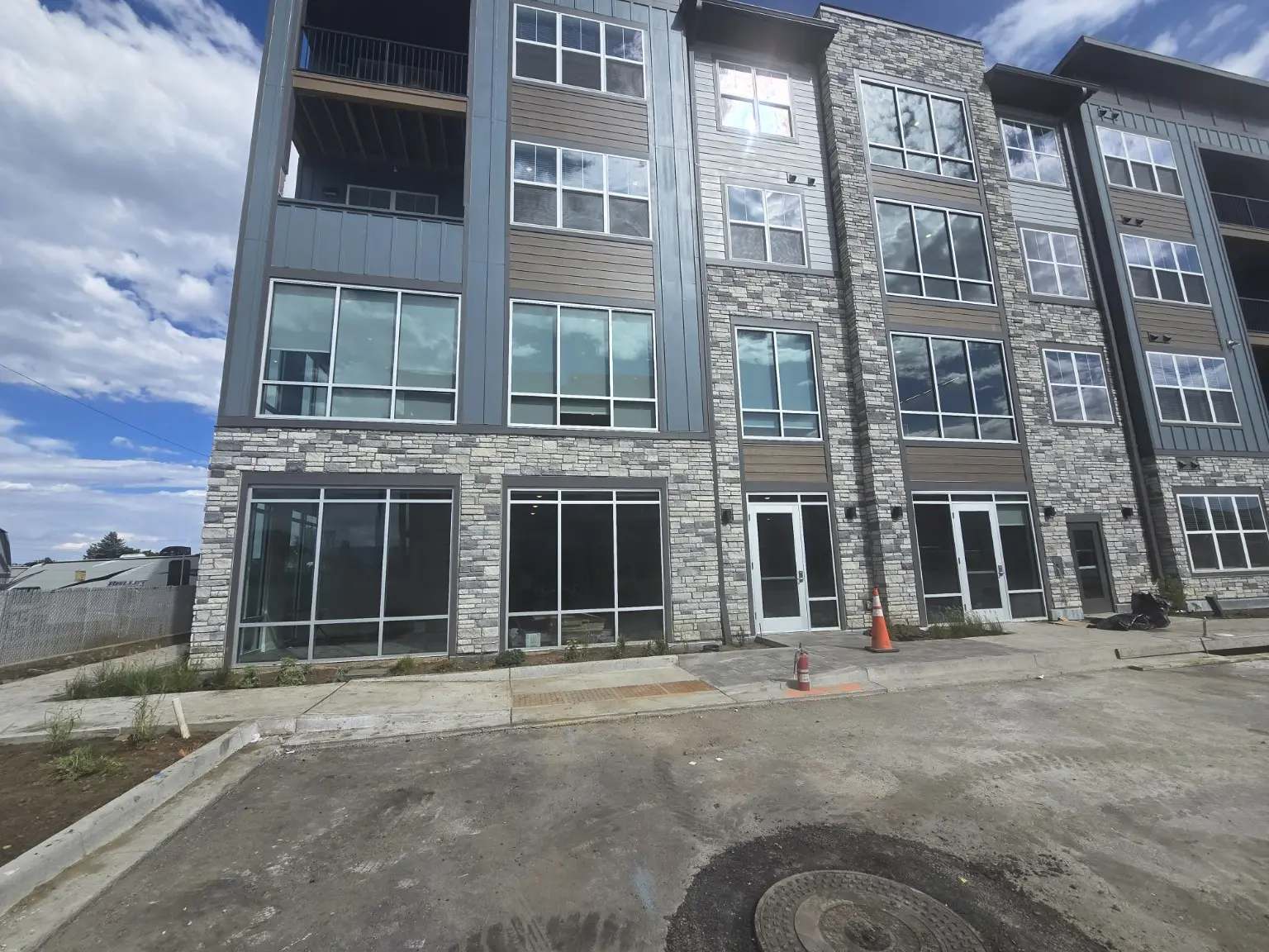 Multifamily building in Thornton Colorado with aluminum windows above ground-floor storefront glazing installed by Abricos Glass