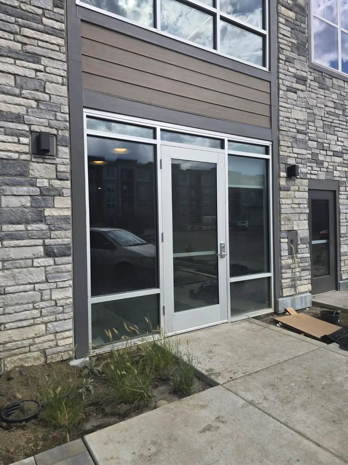 Aluminum commercial entrance door with glazed sidelites and transom at a Thornton multifamily building