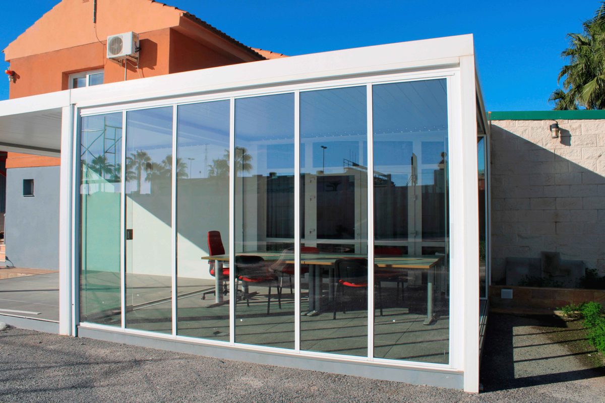 Office space before and after a frameless sliding glass enclosure — Before