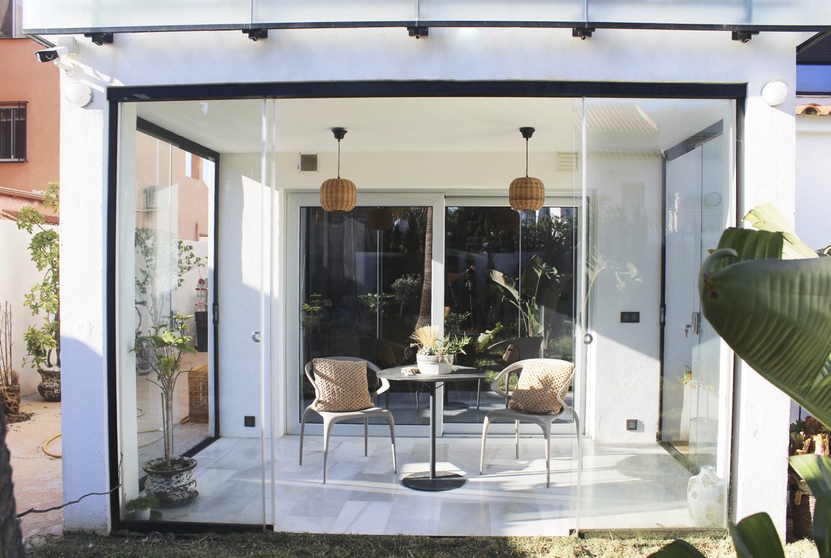 Open patio before and after a frameless glass enclosure — After