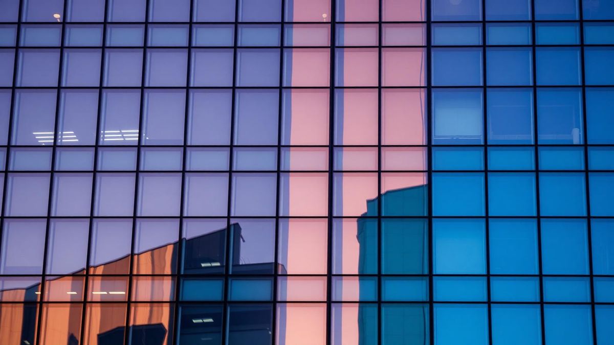 Low-E coated curtain wall glass reflecting sky and neighbouring buildings
